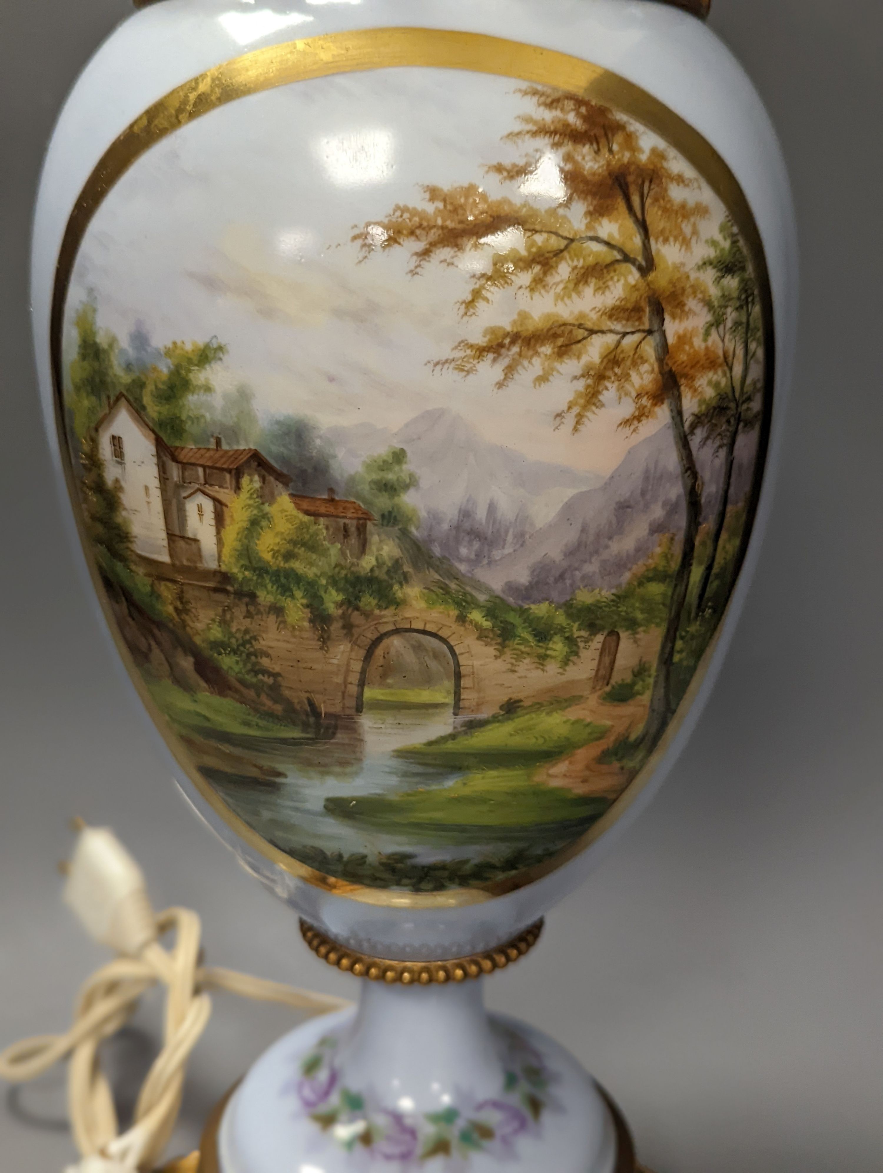 A French 19th century porcelain and ormolu oil lamp (later converted to an eclectic lamp), 54 cms high.